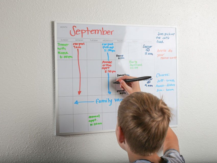 Parent teaching a child how to follow a daily routine using a visual schedule at home